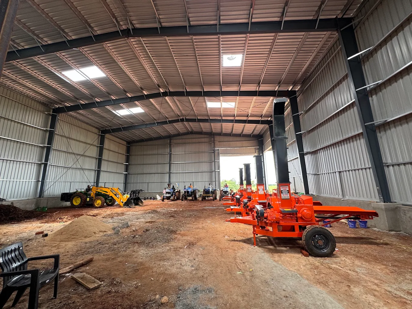 Shredders and tractors inside the Sri Parameswara biomass briquette warehouse